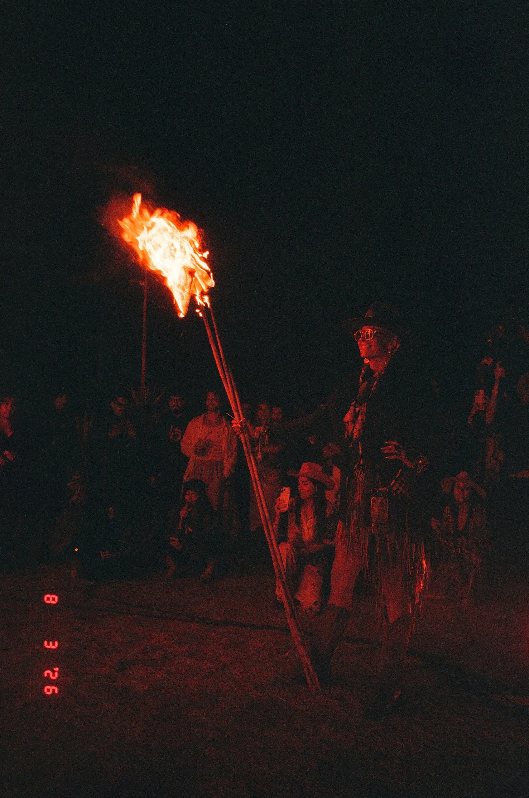 Olivia Steele holding a flaming torch during Amarás Oaxaca Experience 2026, with an audience watching.