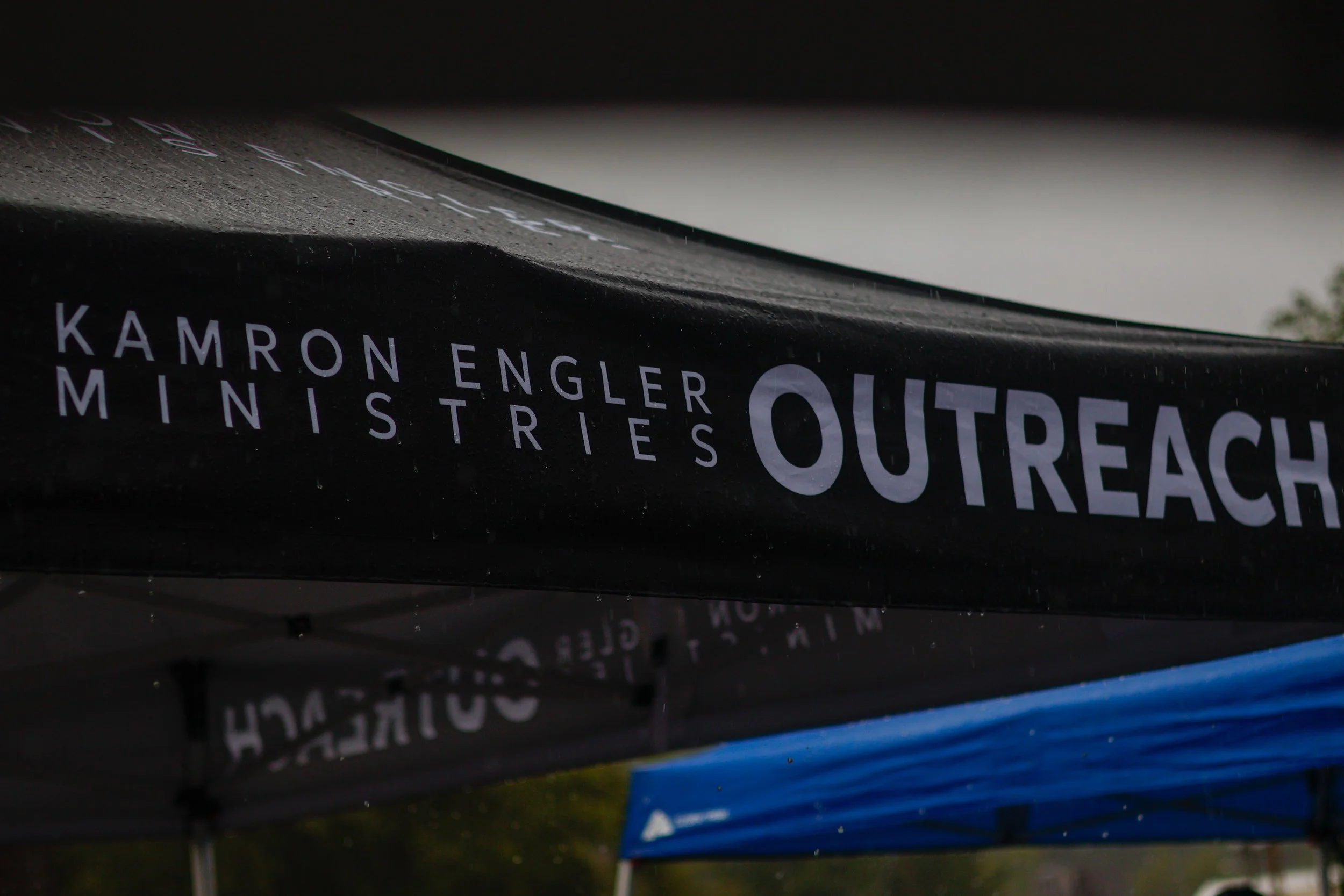 Close-up of books with the title 'Outreach' in focus, with other books stacked underneath and slightly blurred in the background.