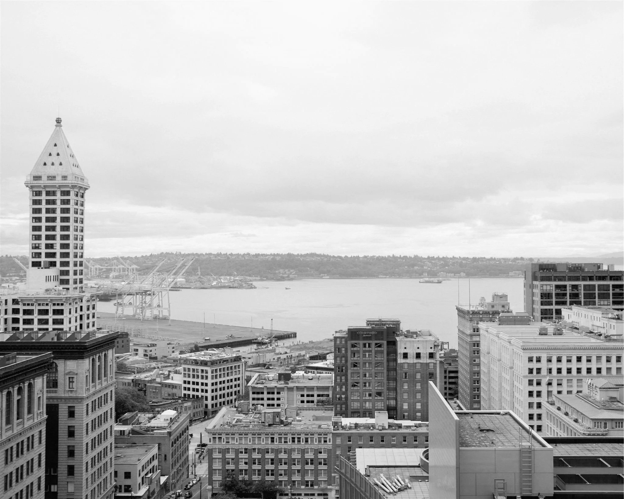 Cityscape of downtown Seattle with Smith Tower and Elliott Bay visible from the Seattle Municipal Courthouse rooftop.
