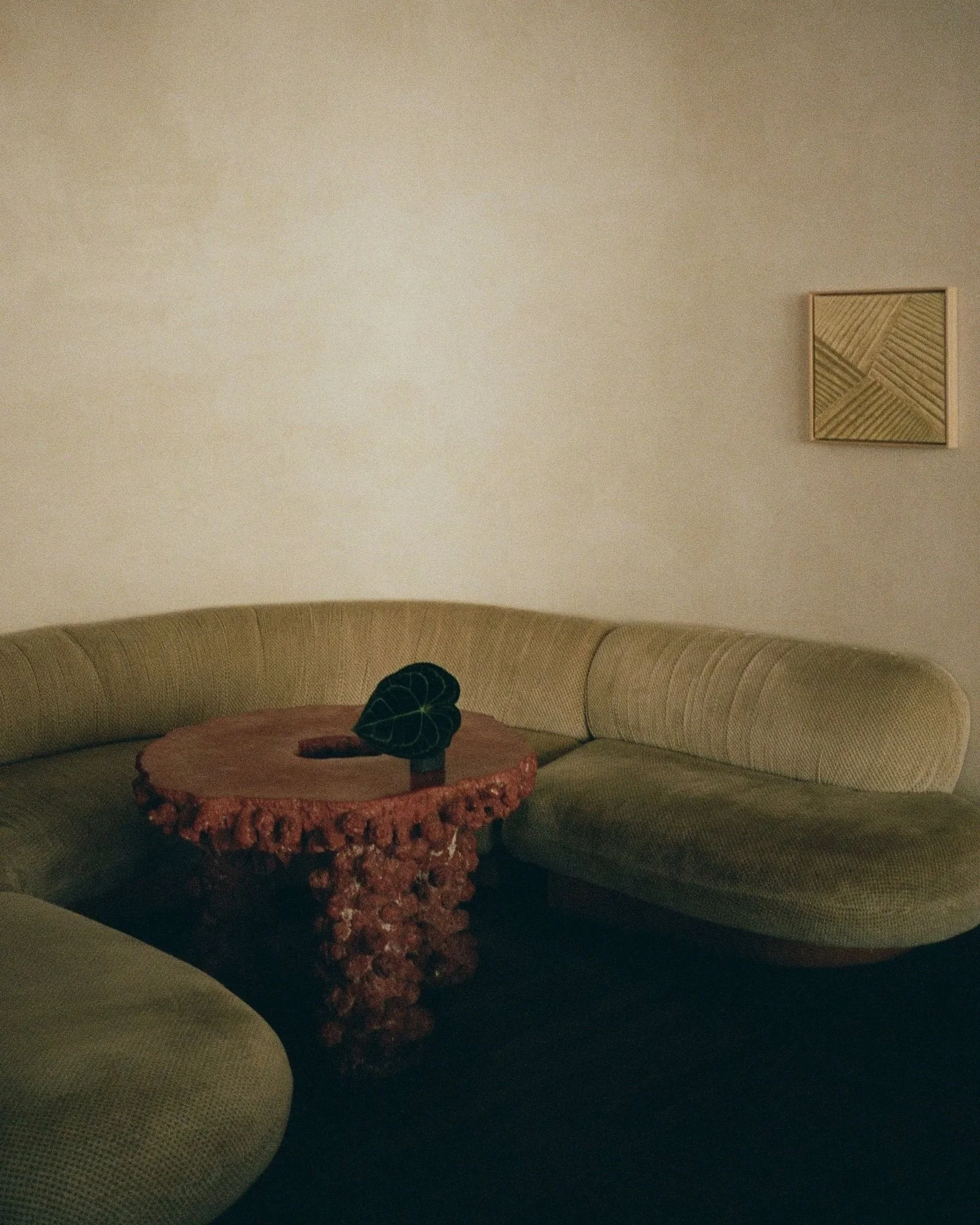 A room with a curved beige sofa, at The Proper hotel in Santa Monica, California.