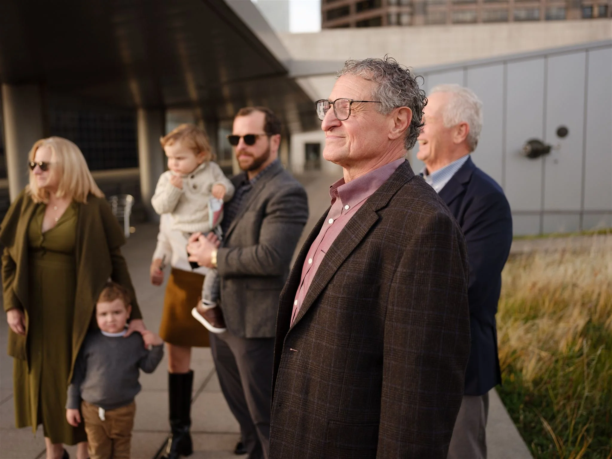 Family members and guests gathered outside the Seattle Municipal Courthouse, watching an intimate wedding celebration unfold on a sunny afternoon.