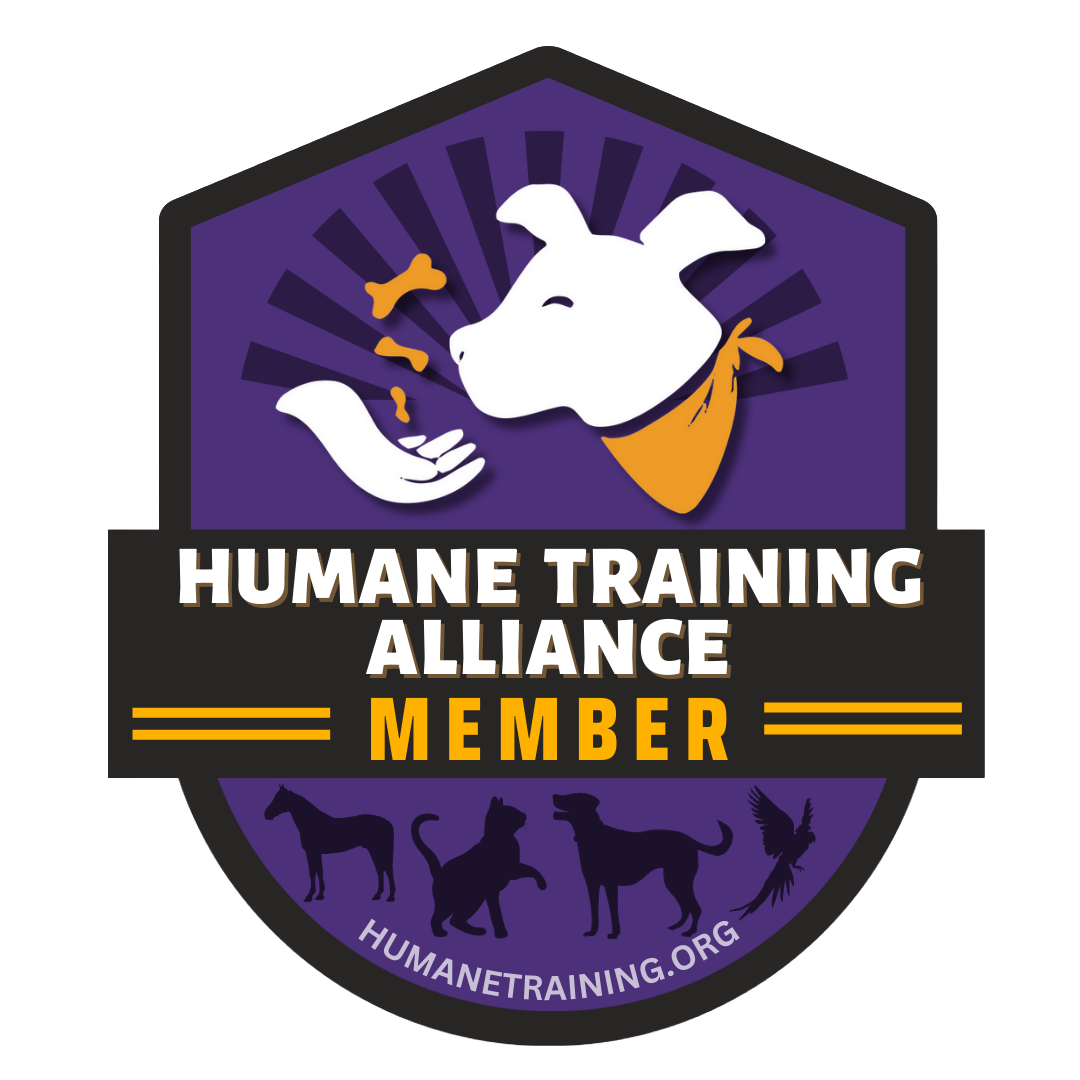 A badge for the Humane Training Alliance featuring a white dog with a yellow bandana, chewing a bone, with silhouettes of a horse, cat, dog, and parrot below, and the website humane training.org.