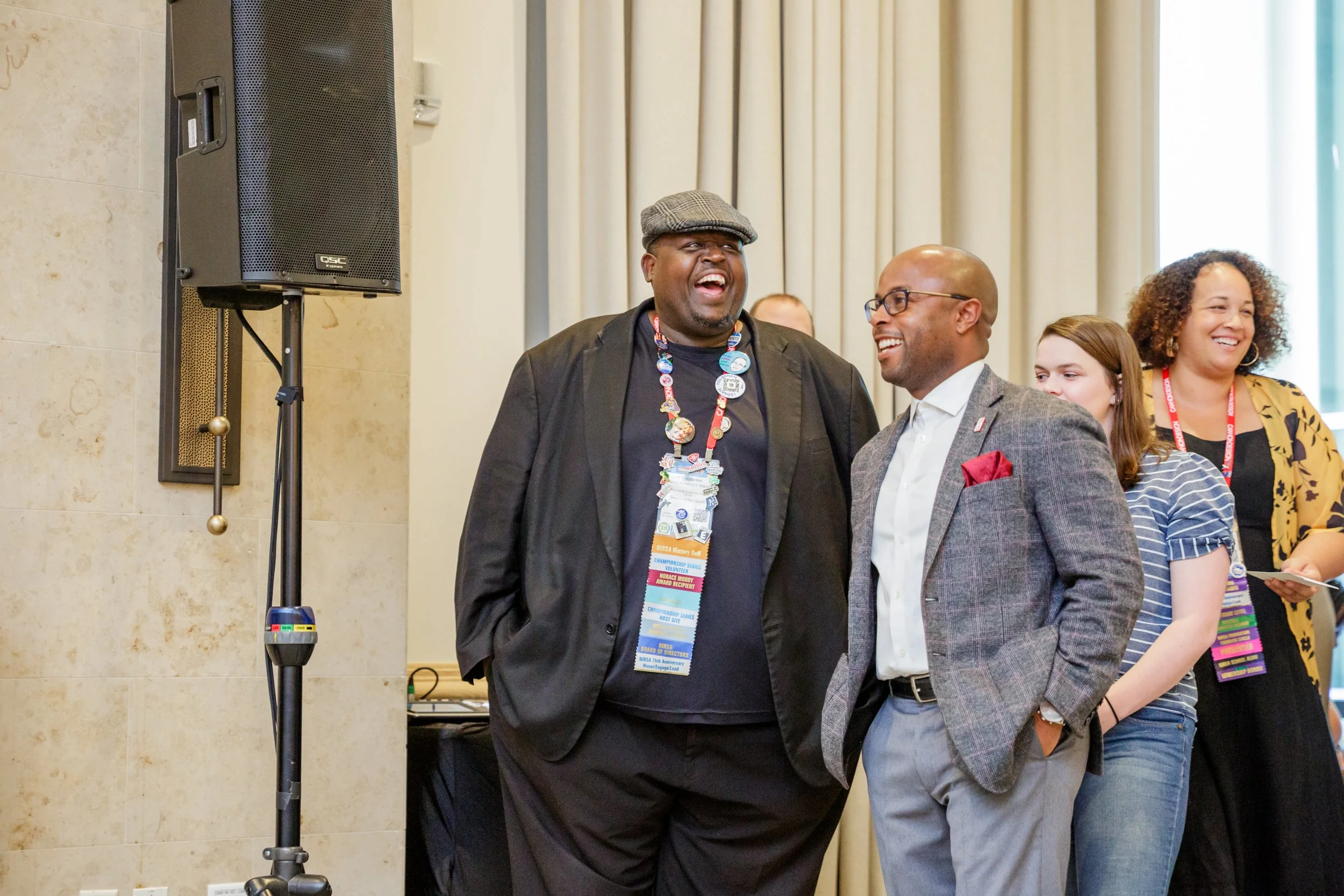 This is Dr. Dexter Shorter with a small group of people smiling and laughing indoors, wearing conference badges.