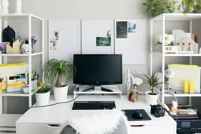 A neatly arranged work desk setup with office supplies and technology.