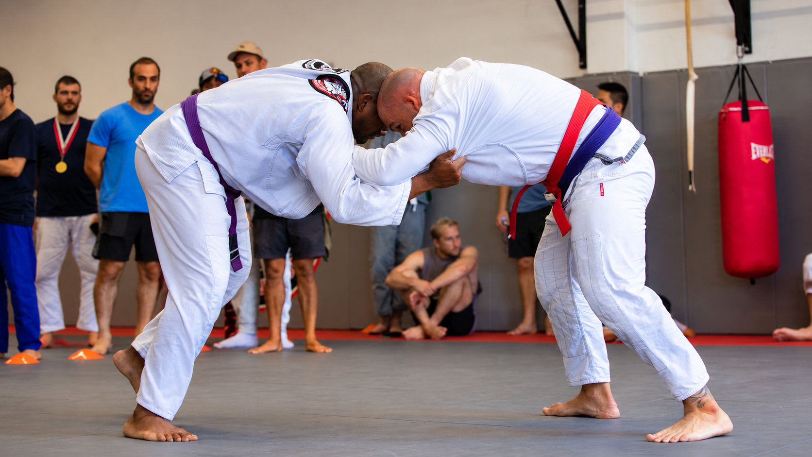 Brazilian Jiu Jitsu athletes practicing grappling techniques during a training session.