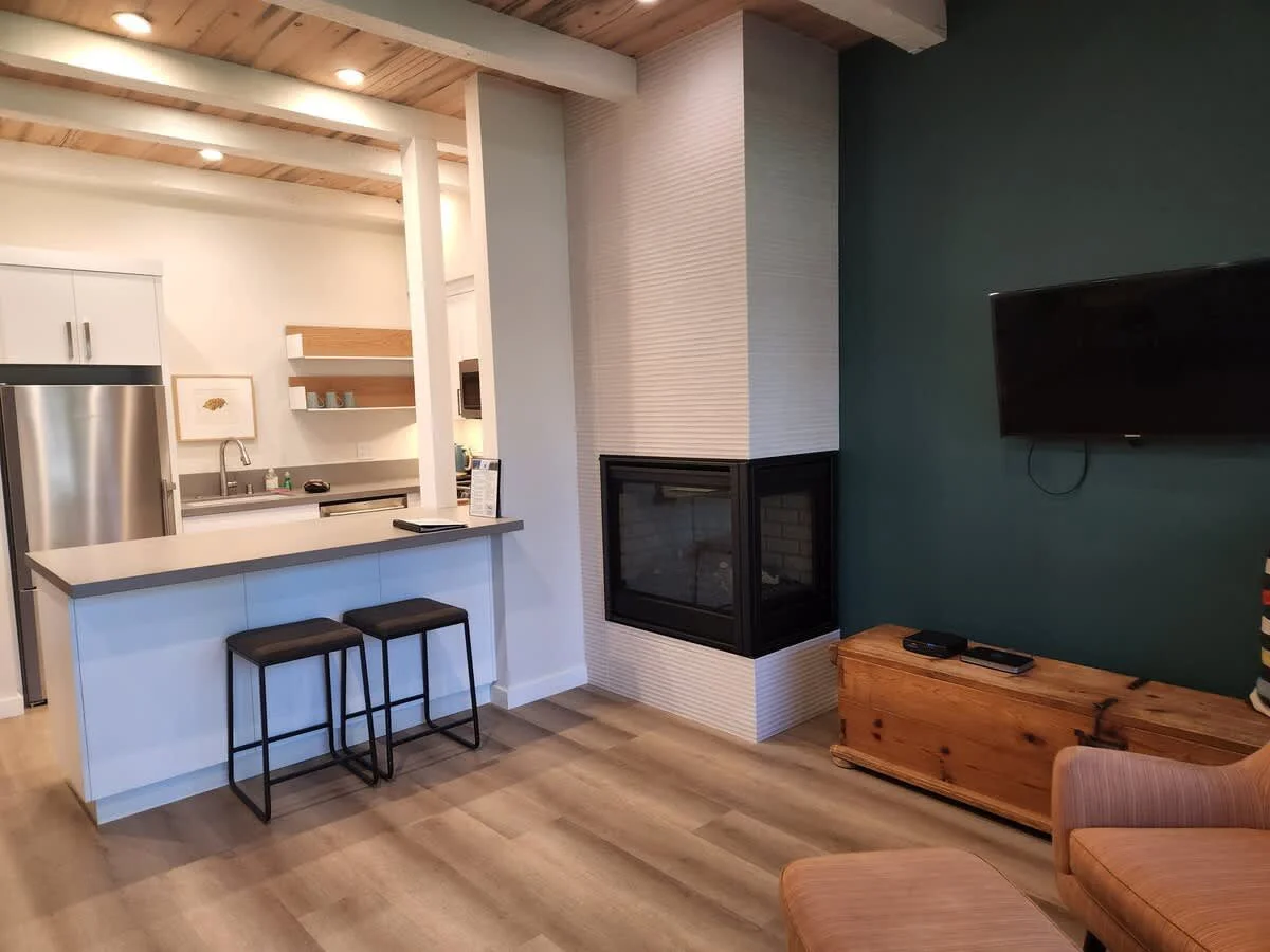breakfast bar and view of gas fireplace, and kitchen with white cabinets and stainless appliances