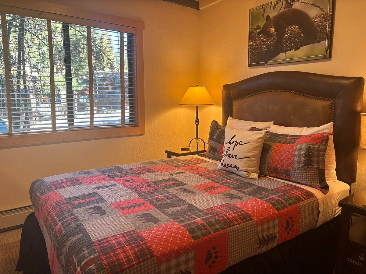 main bedroom with leather headboard, lamp