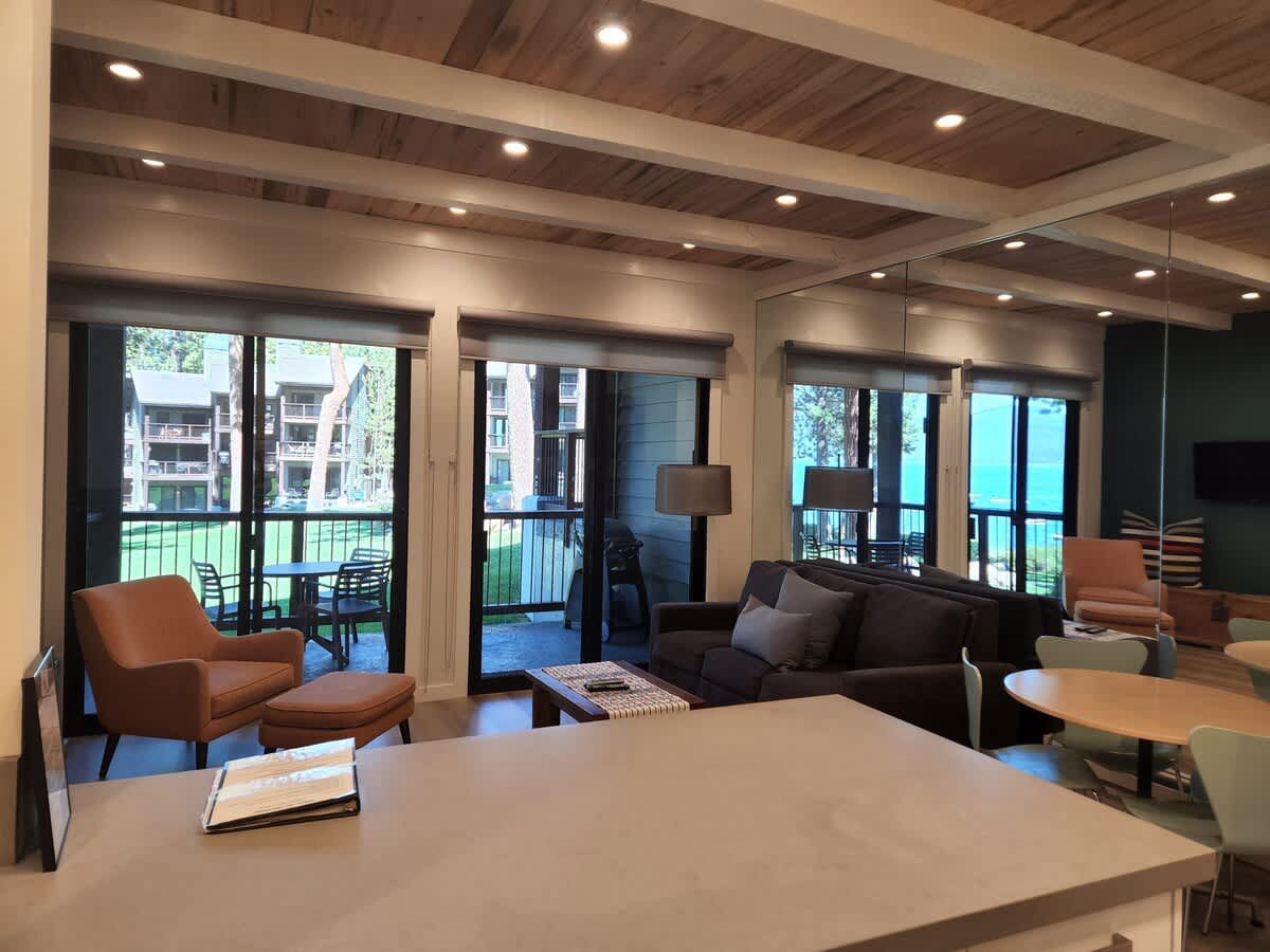 view of living room from kitchen showing view of lawn and lake through sliding doors