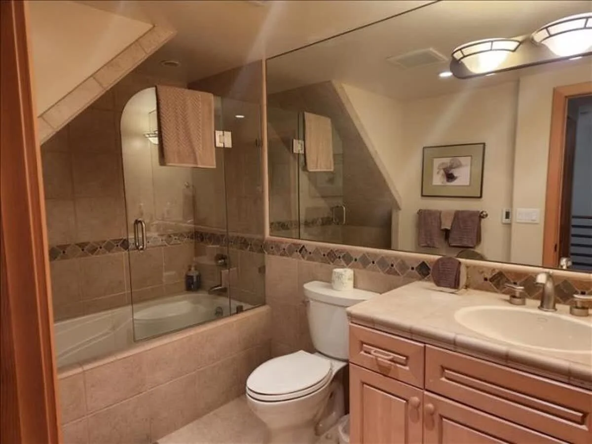 bathroom with tile floor, counters, and shower with glass doors, large mirror over sink