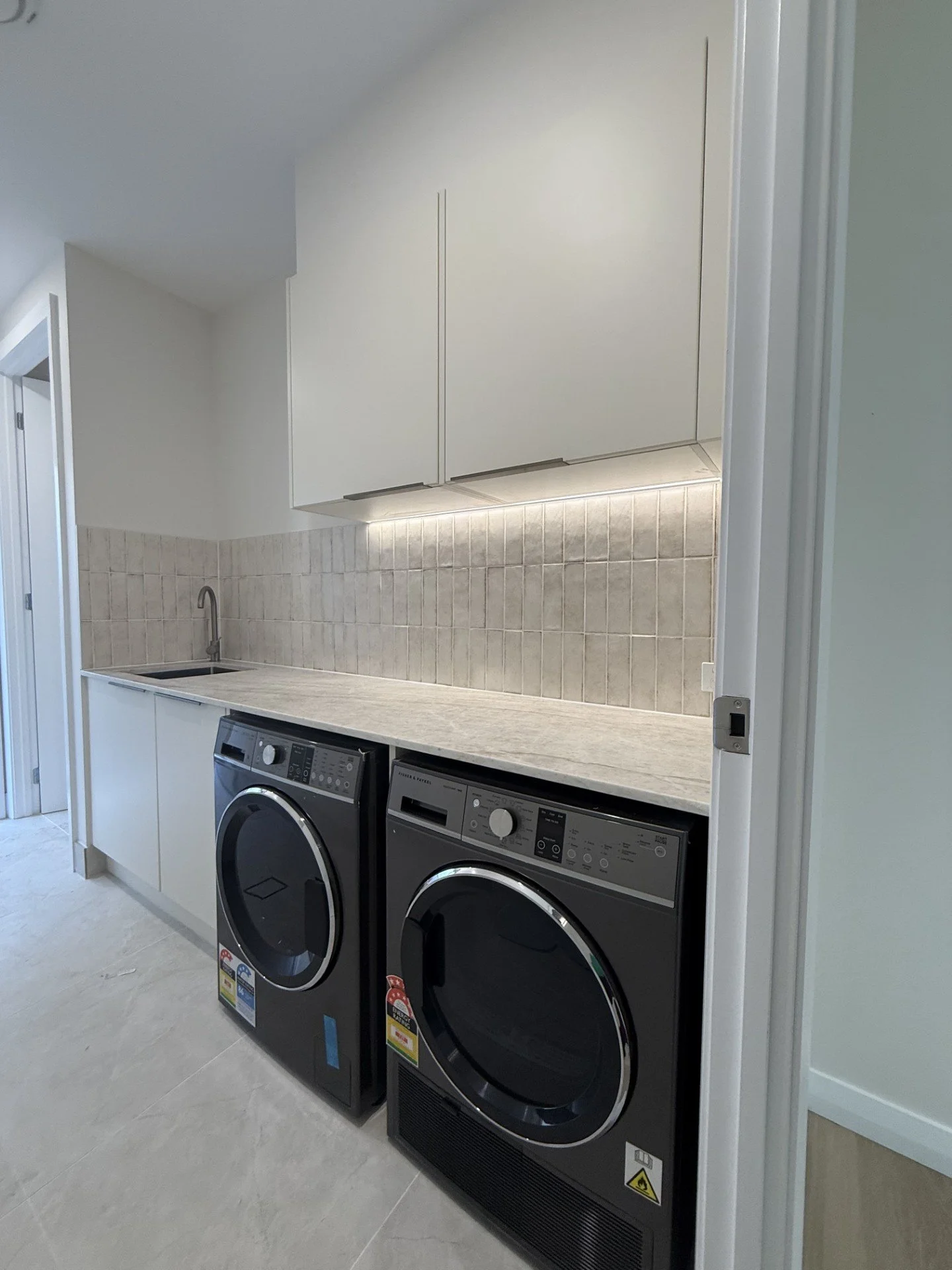 Laundry room with a countertop, cabinets, a sink, and a washing machine and dryer.