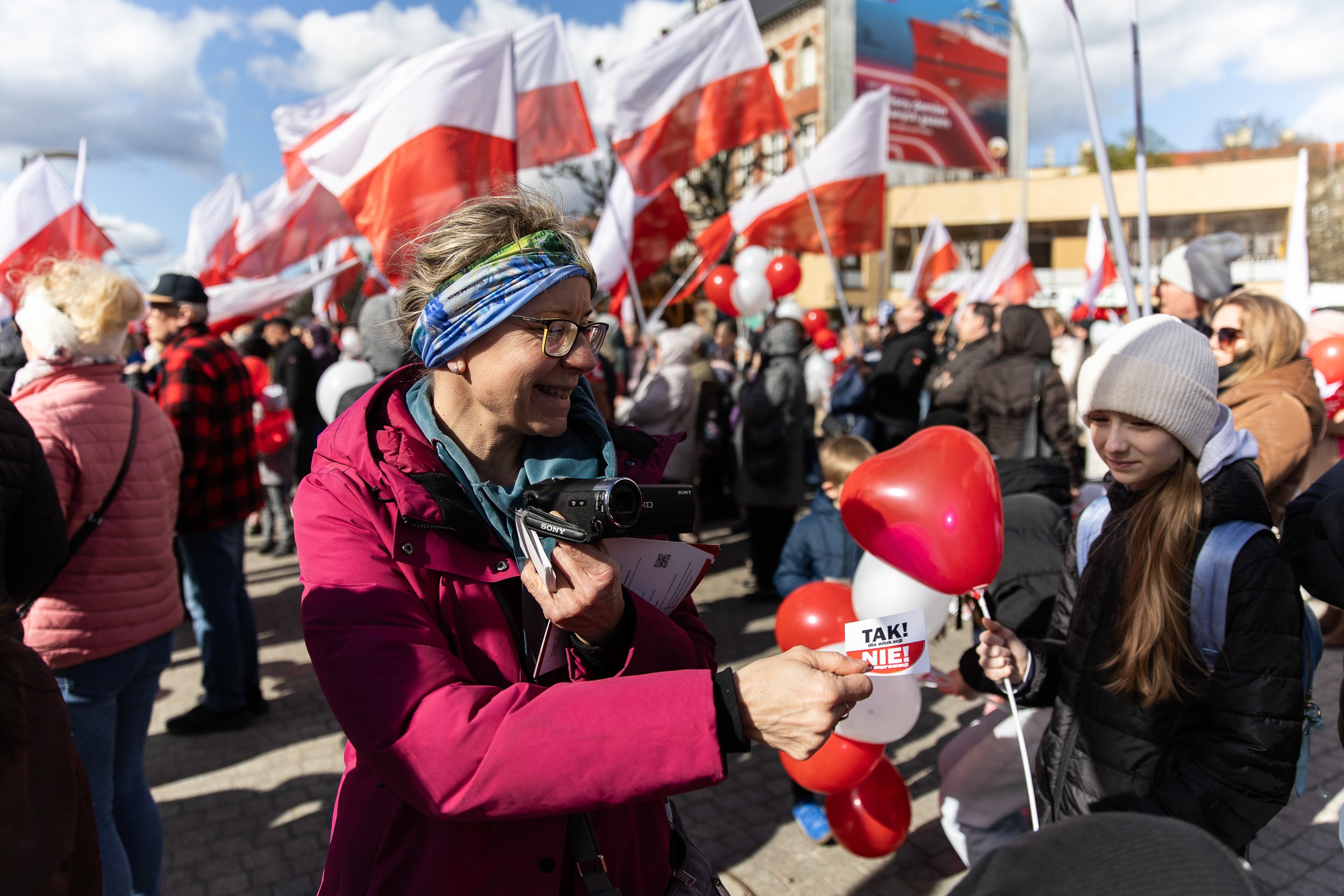 A person handing out stickers during the "YES to education! NO to depravity!" protest, Paweł Adamowicz Square, Szczecin, Poland, April 5, 2025