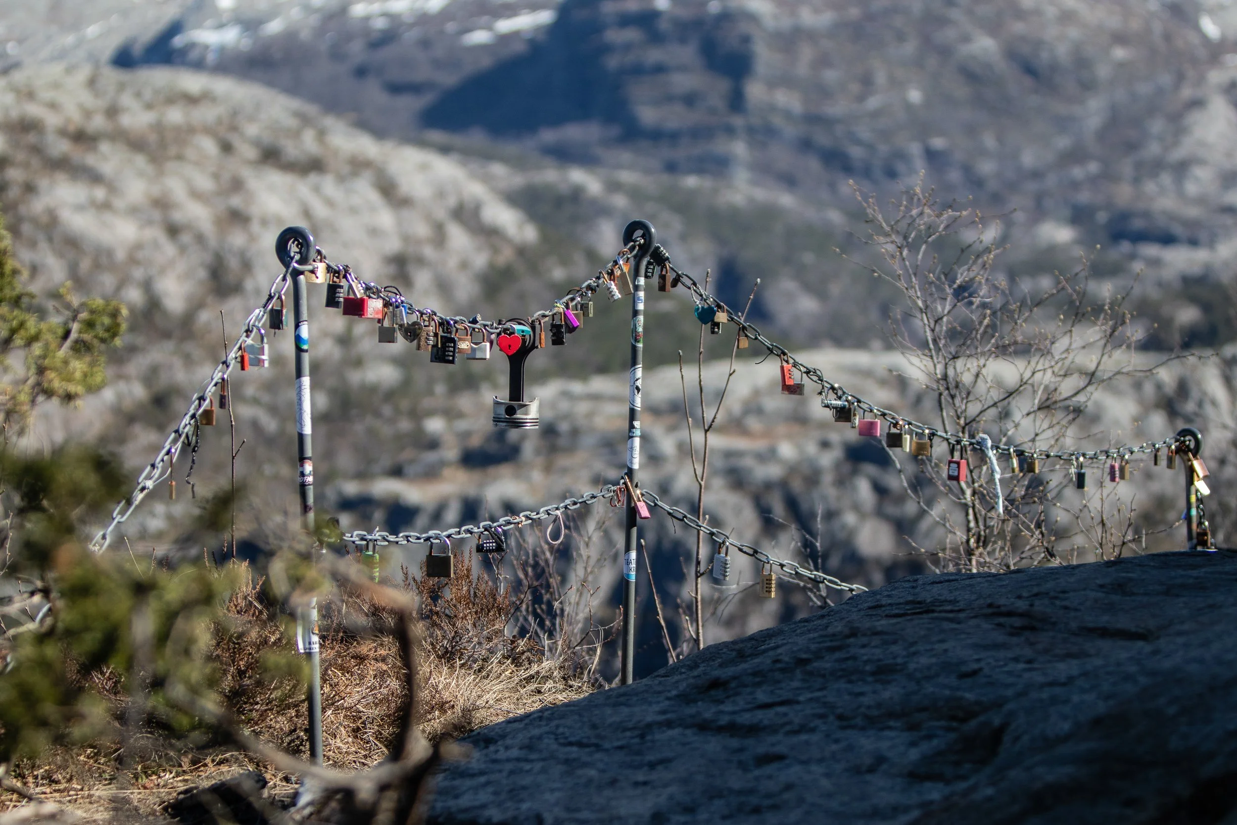 Hanging padlocks and other items on the trail leading to Preikestolen (Pulpit Rock), Norway, April 22, 2023