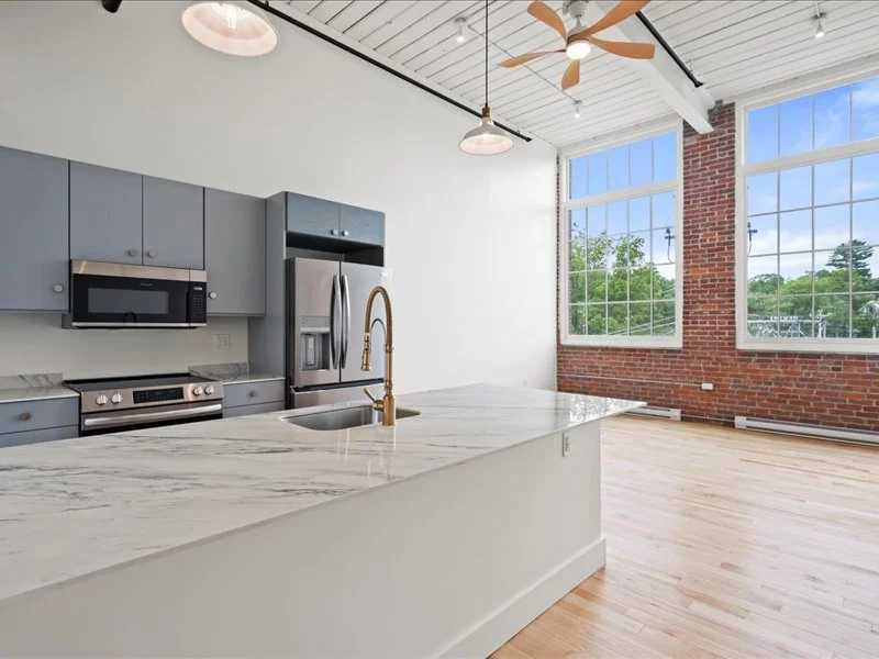 The Spinning Mill - In-unit stacked washer and dryer inside apartment laundry closet