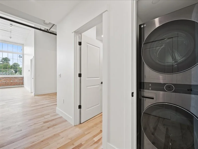 The Spinning Mill - Apartment hallway leading to bedroom with hardwood floors and natural light