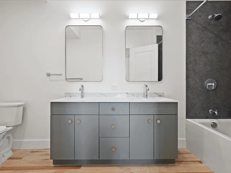 The Spinning Mill - Double-sink bathroom vanity with mirrors, modern lighting, and clean finishes