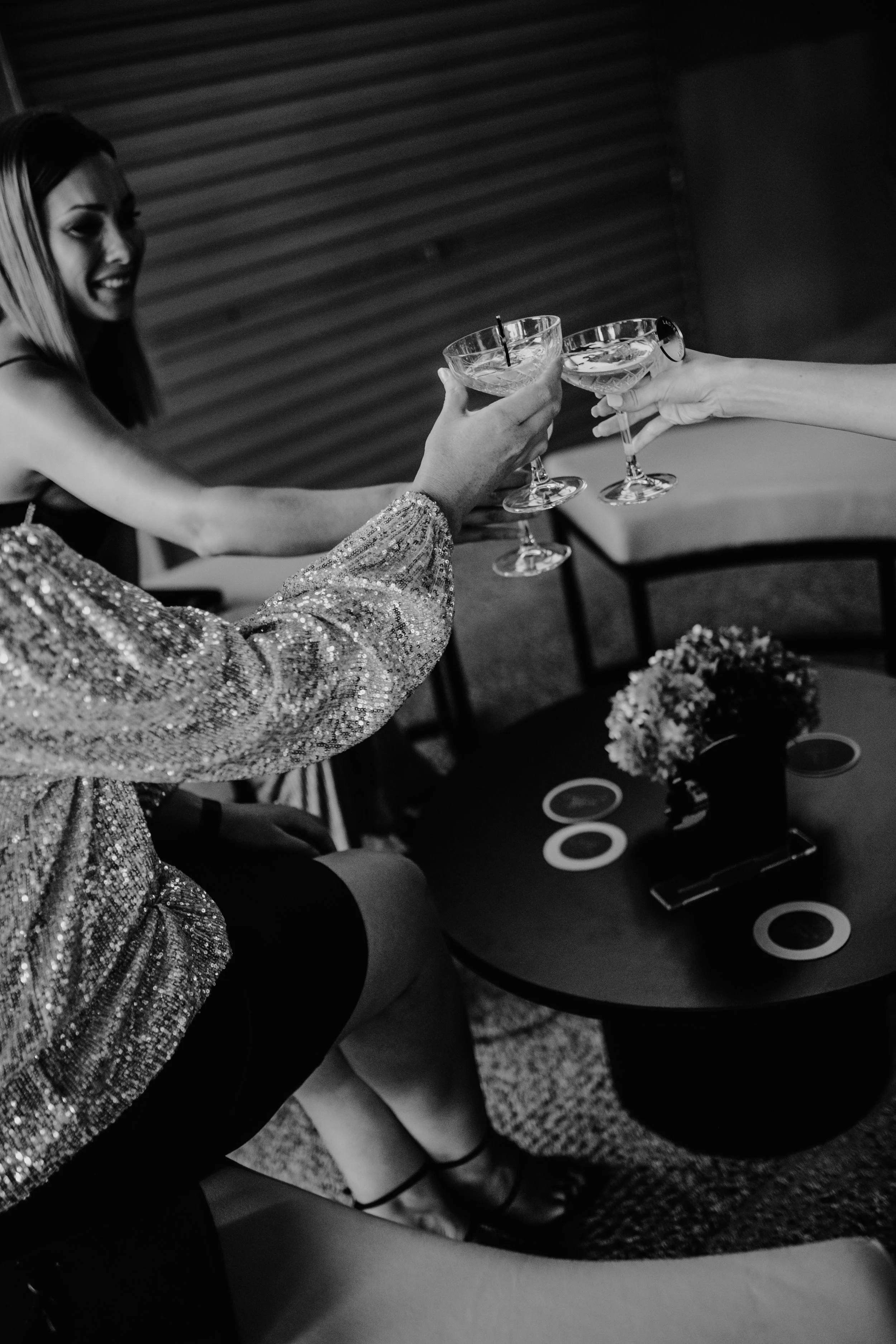 People clinking cocktails in a celebratory toast at a social gathering.