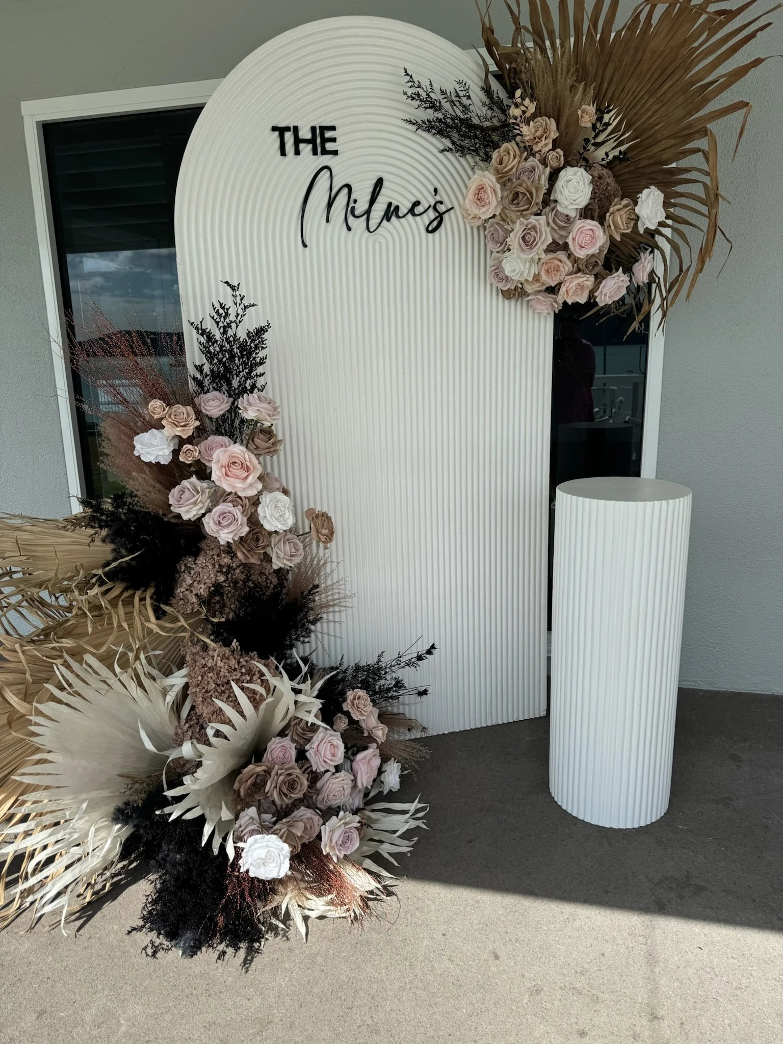 Guest registration backdrop with floral arrangements for Millne's event