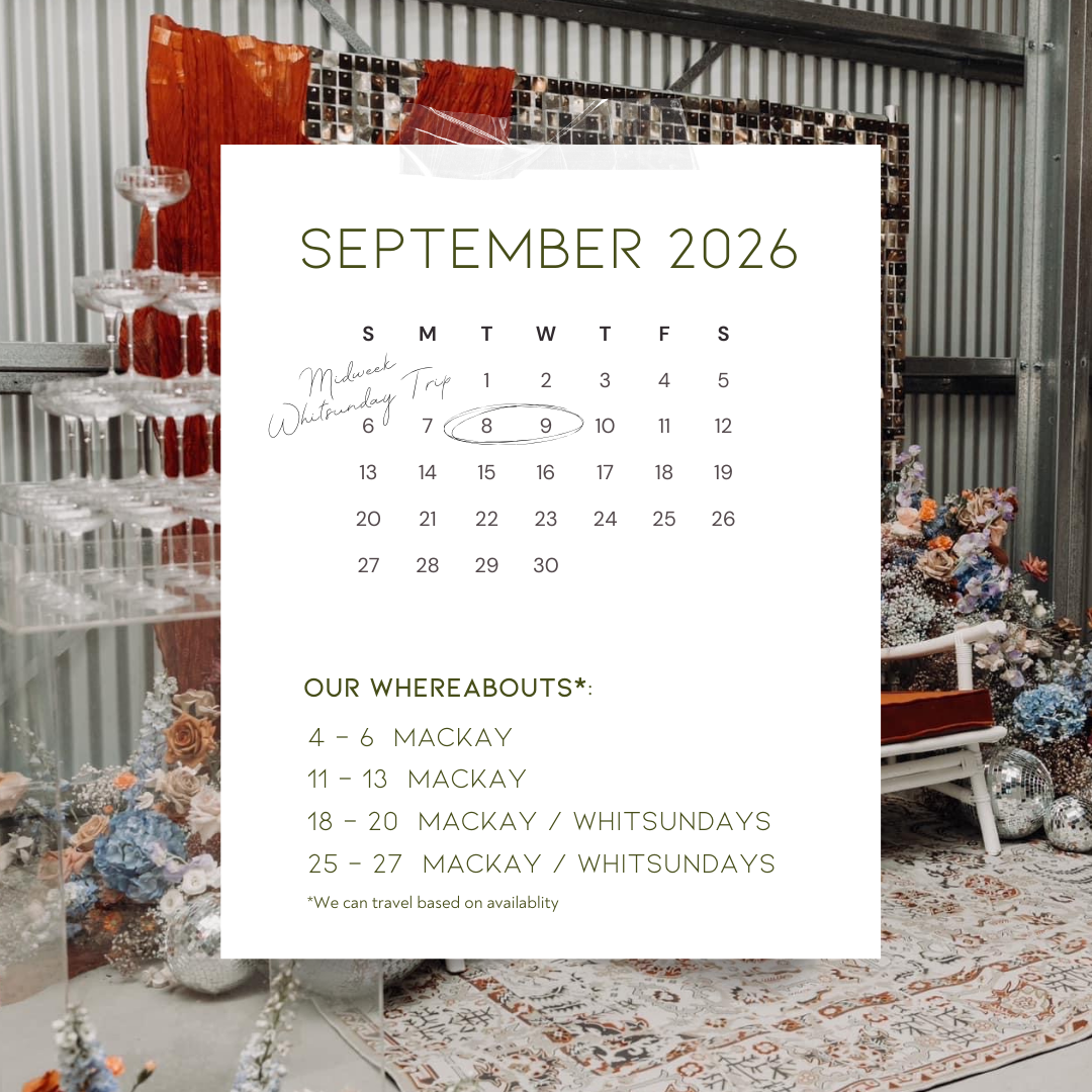 A calendar for September 2026 with handwritten notes indicating a midweek trip on September 8th and 9th. The background shows an indoor setting with a decorative arrangement of flowers, glassware, and a patterned rug.