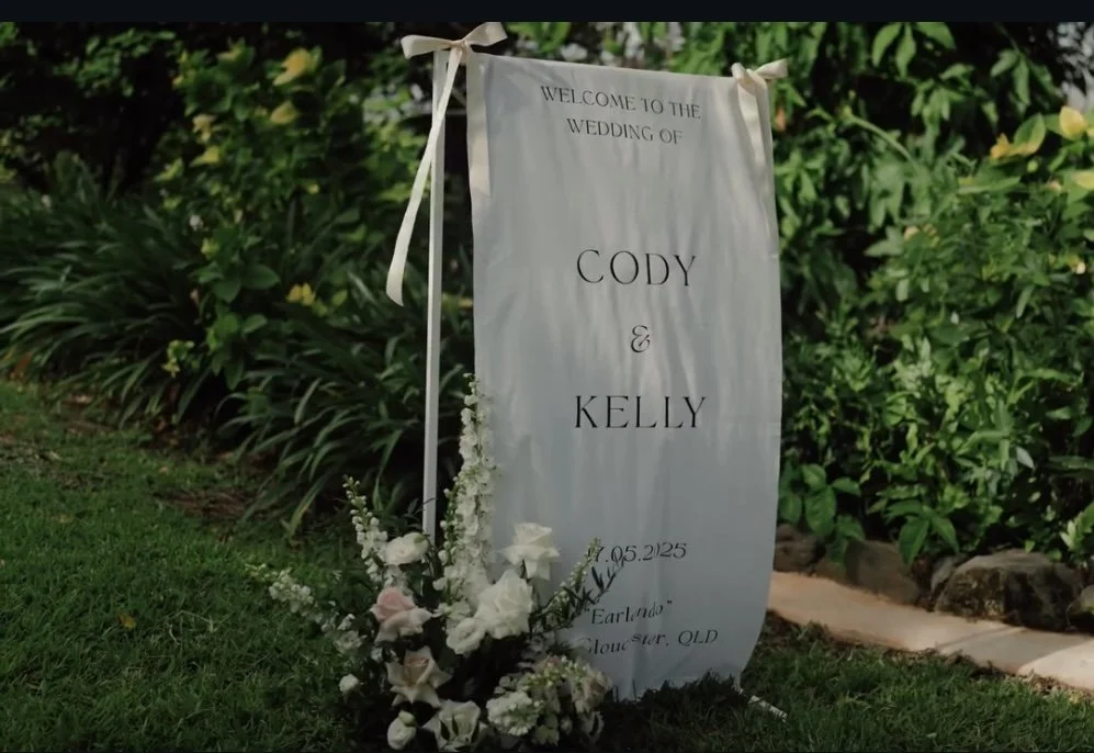 Wedding welcome sign with flowers and greenery background.