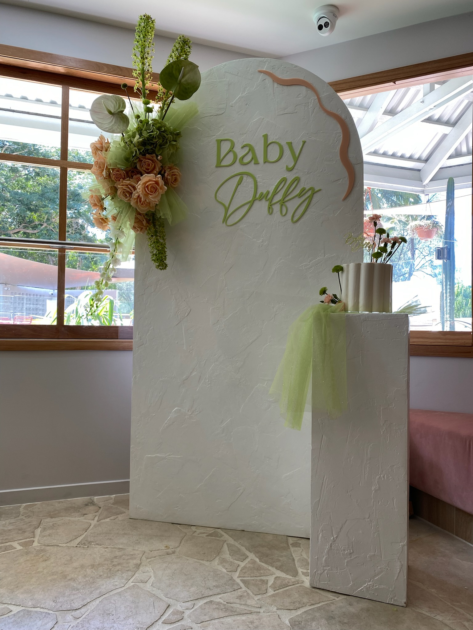 Decorative display with a banner reading "Baby Duffy," decorated with flowers and tulle fabric.