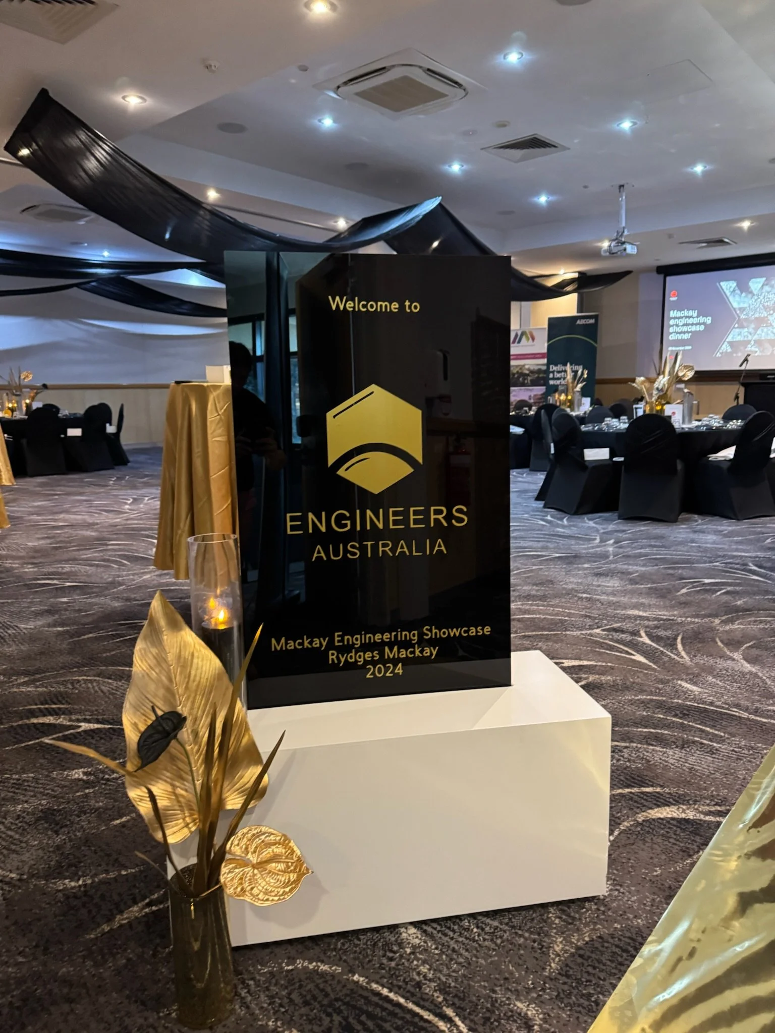 Event sign for Engineers Australia at the Mackay Engineering Showcase Rydges Mackay 2024, with black and gold decor in a banquet hall.