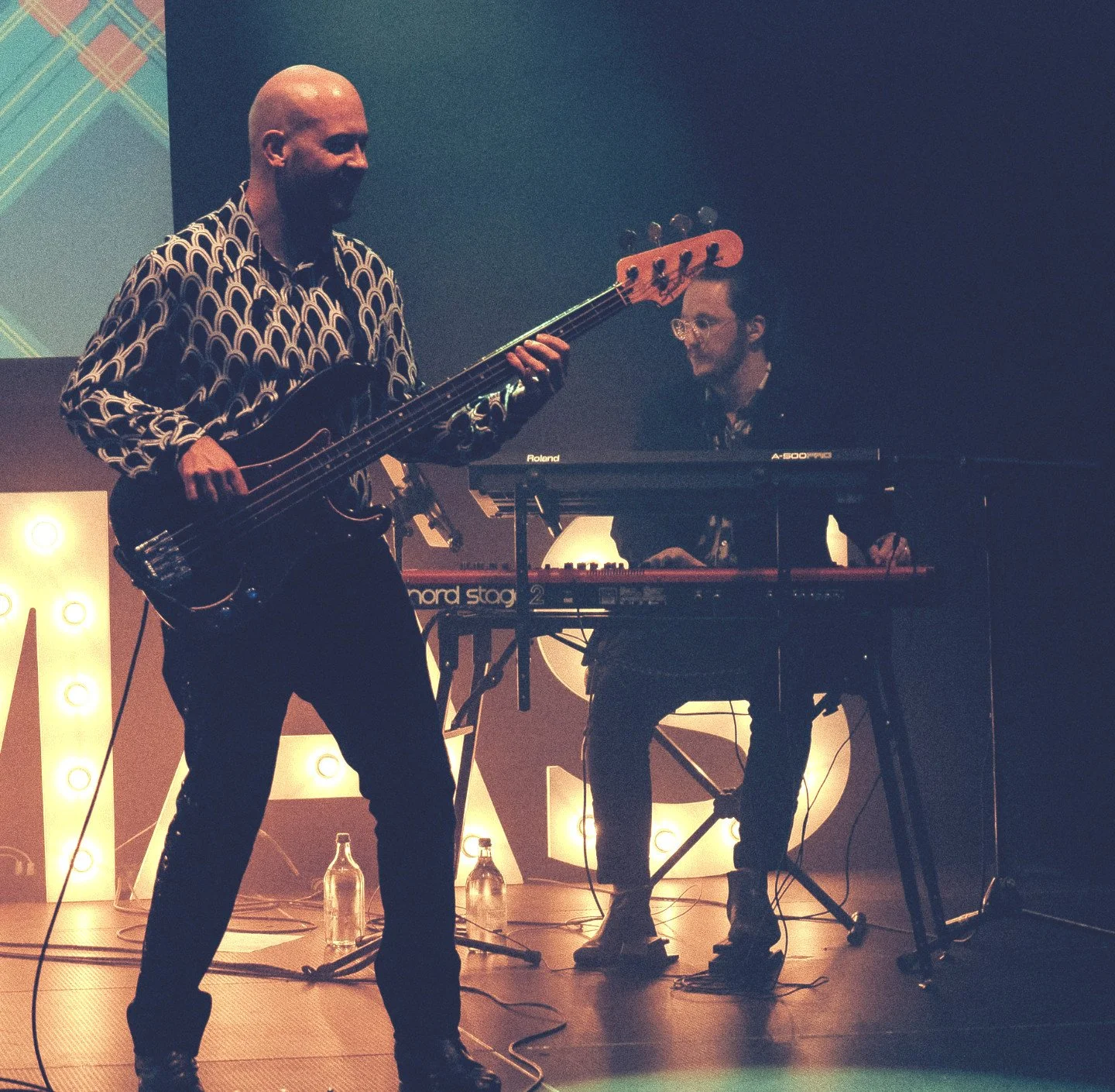 Bassist Sebastian Braun und Keyboarder Lion Wegmann auf der Bühne bei einem corporate Event in der Schweiz.