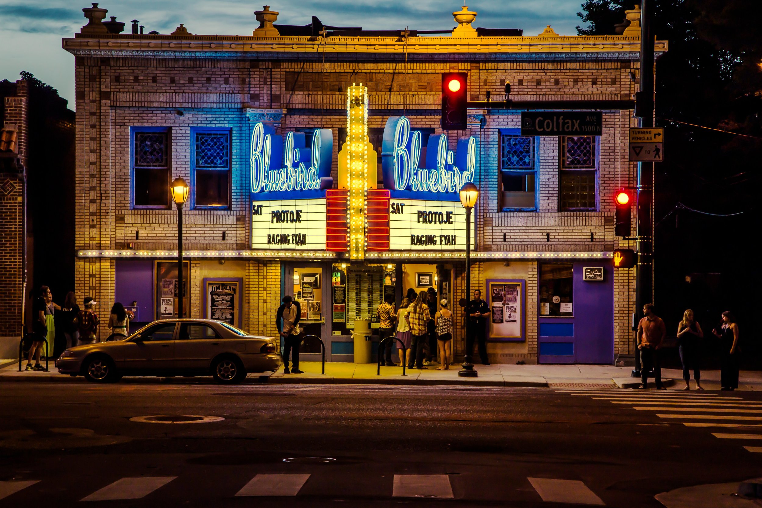 Night view of Bluebird Theater with illuminated marquee and people outside
