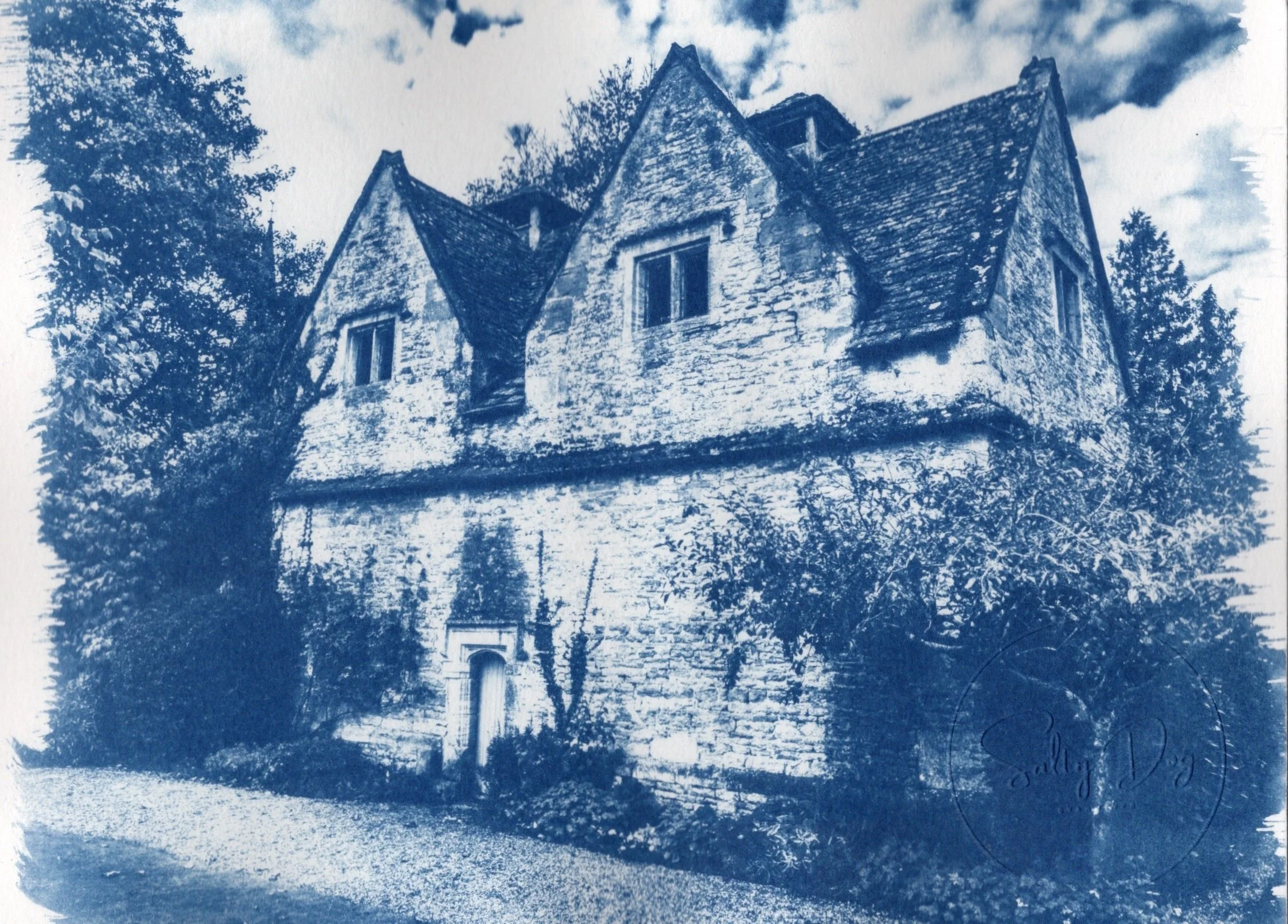 Cyanotype photo of a pigeon coup with gabled roof and foliage, Lower Slaughter, the Cotswolds