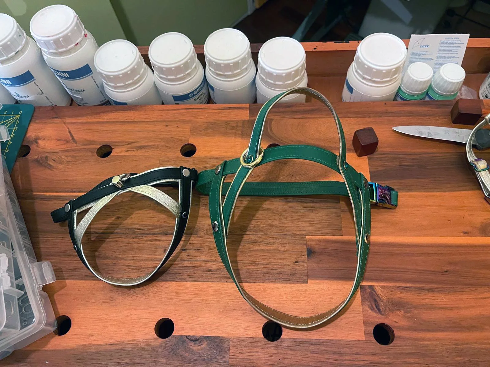 Due collari per animali, uno verde e uno nero con grigio, posti su un tavolo di legno.