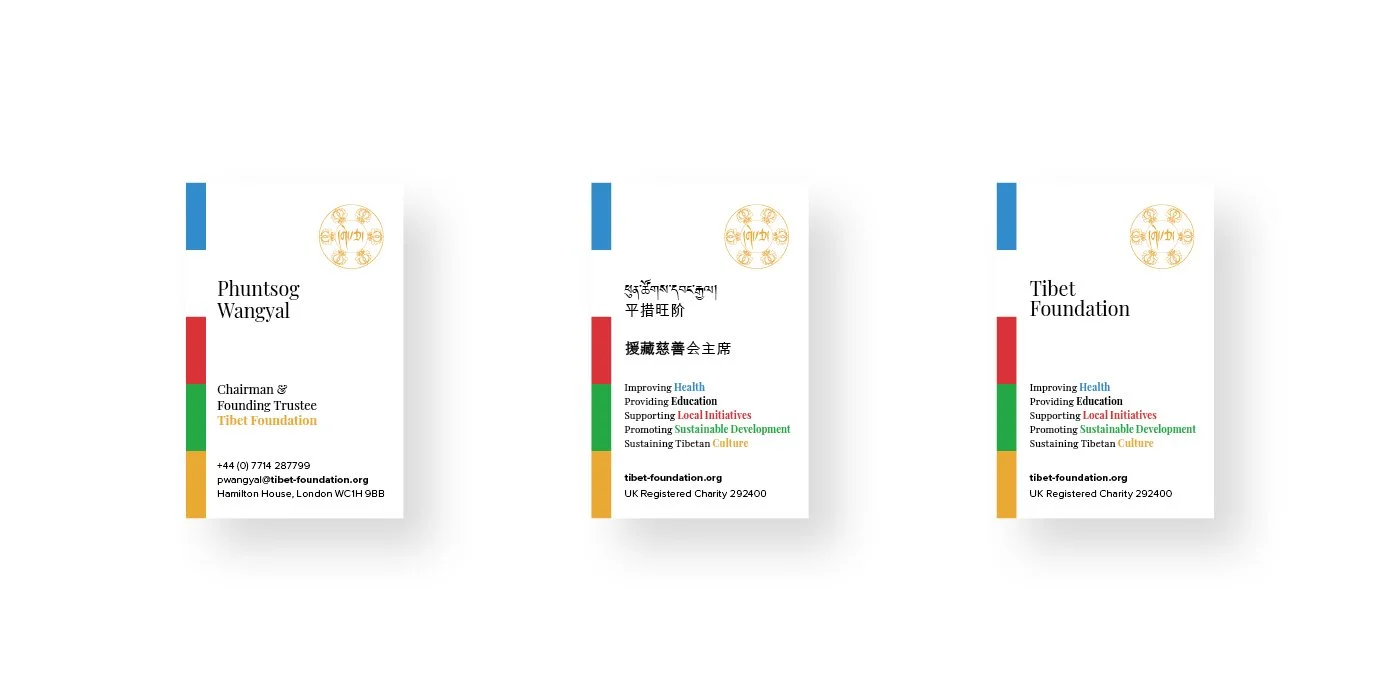 Business cards combining multilingual typography with distinctive colour bands, carrying the refreshed identity into everyday communications.