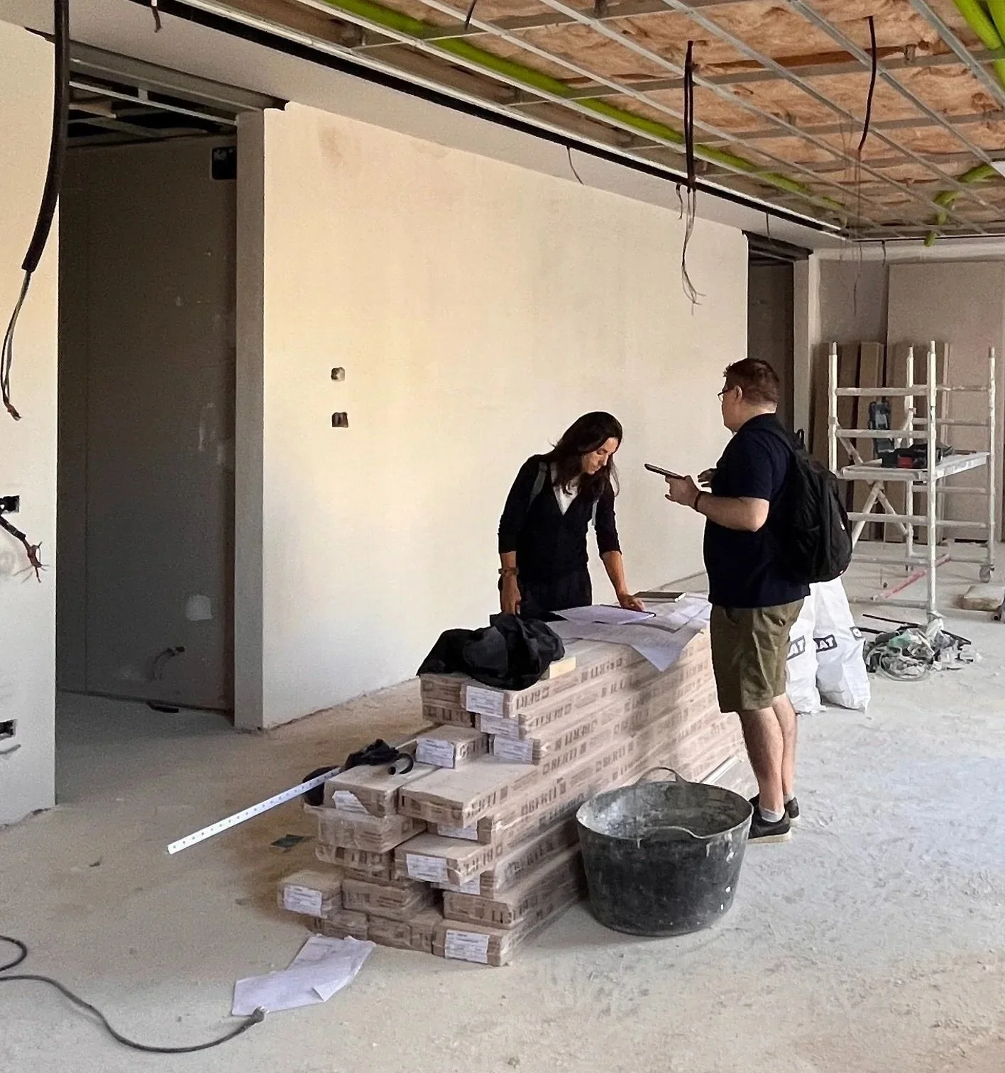 Profesionales revisando planos y coordinando el avance de una reforma en el interior de una obra en construcción