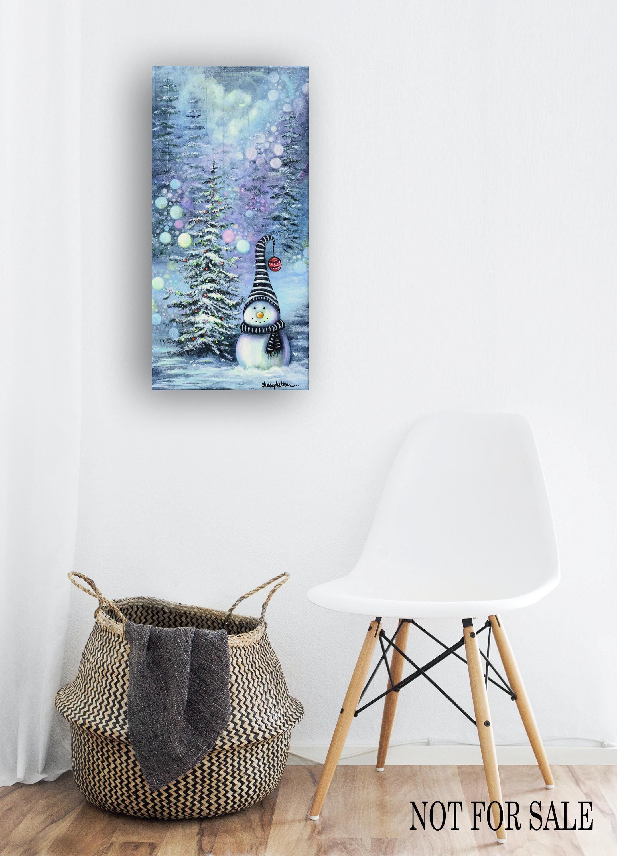Snowman with black and white gnome hat next to a lighted snowy christmas tree in a snowy blue landscape