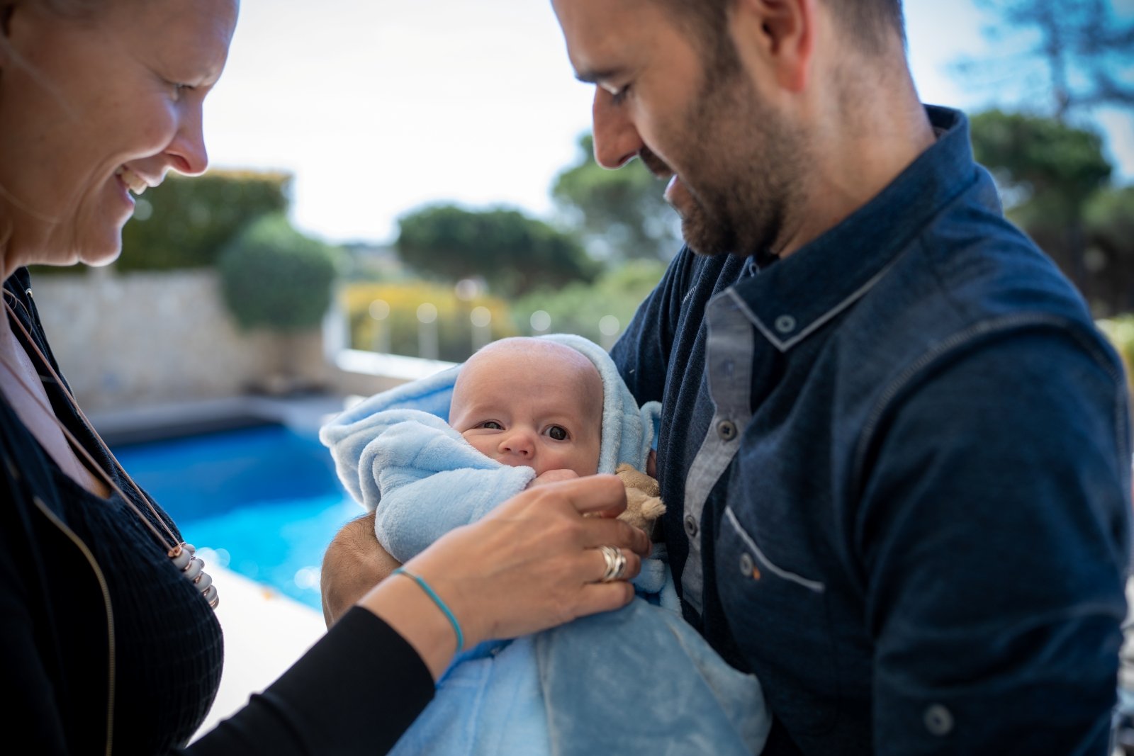 mom and dad wrap baby in a blanket by Michelle Molnar photography