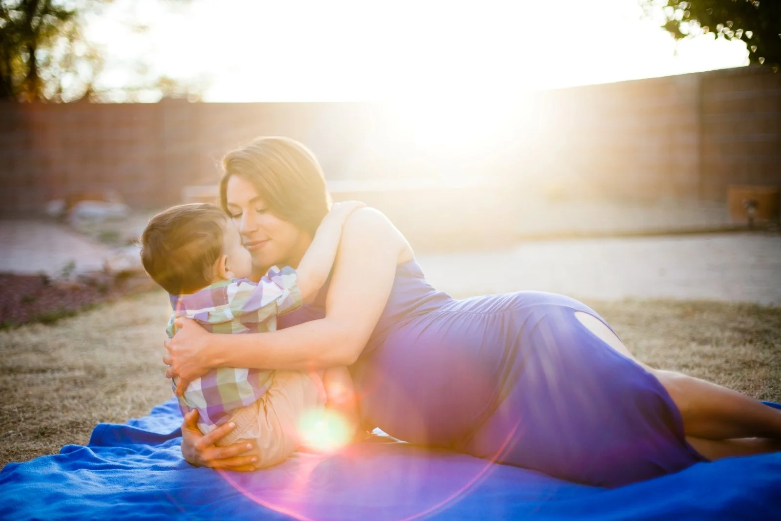 Pregnant Mom and her son cuddle in the grass during a North County San Diego maternity session.