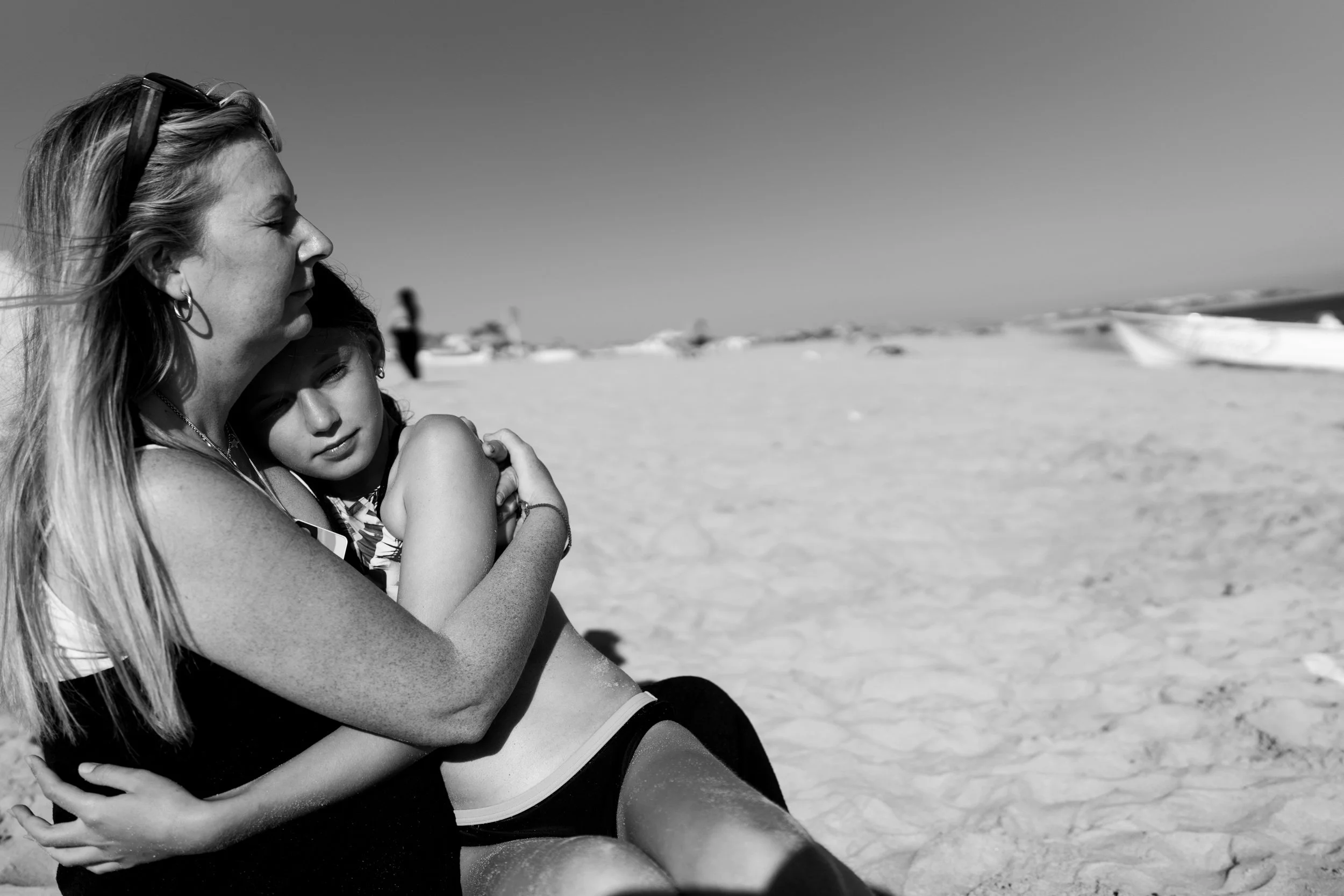 A mom and daughter hug on a beach by Tucson family photographer Michelle Molnar.