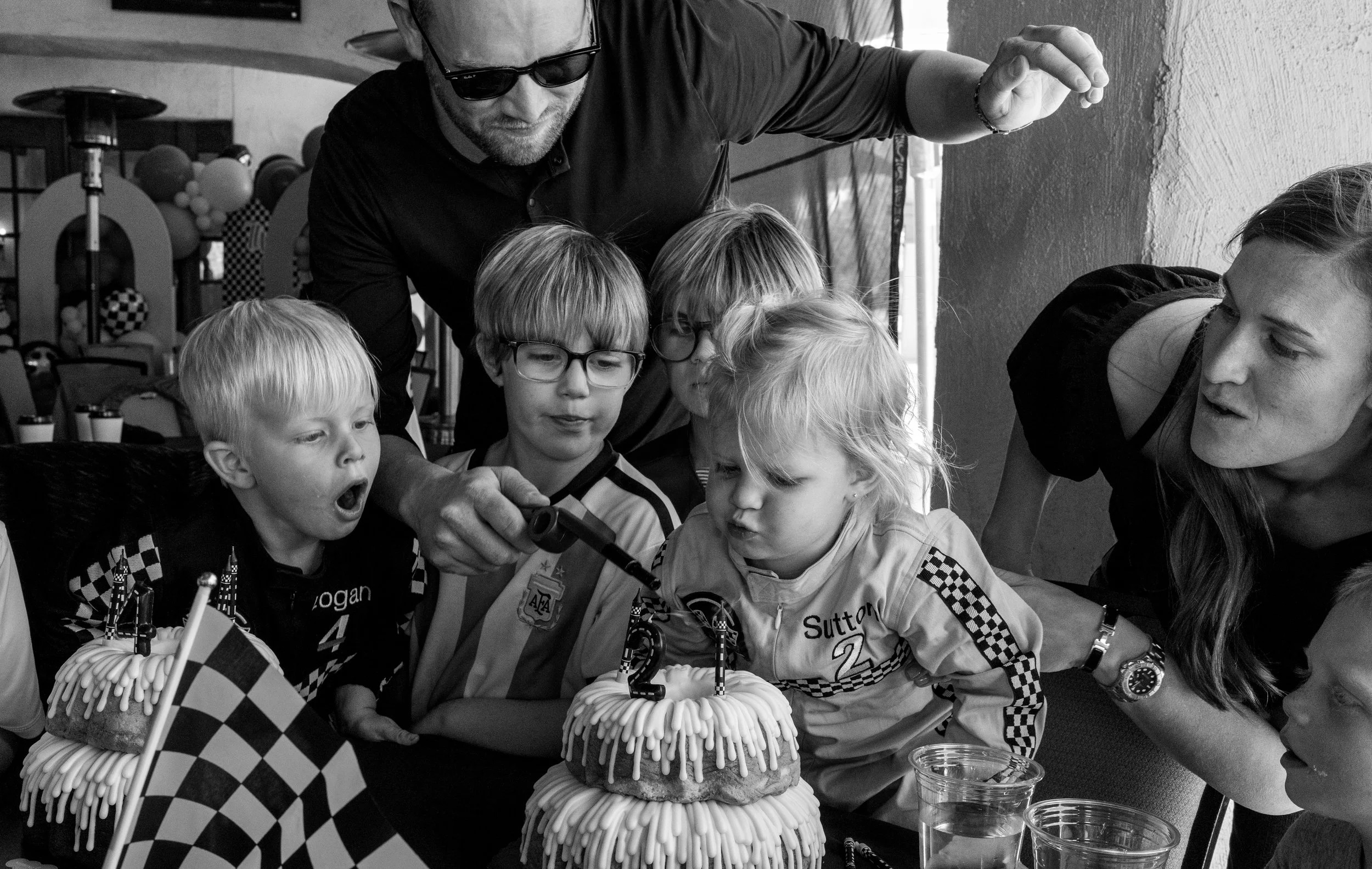 Kids blow out birthday cake candles during a Tucson Birthday party photography session.
