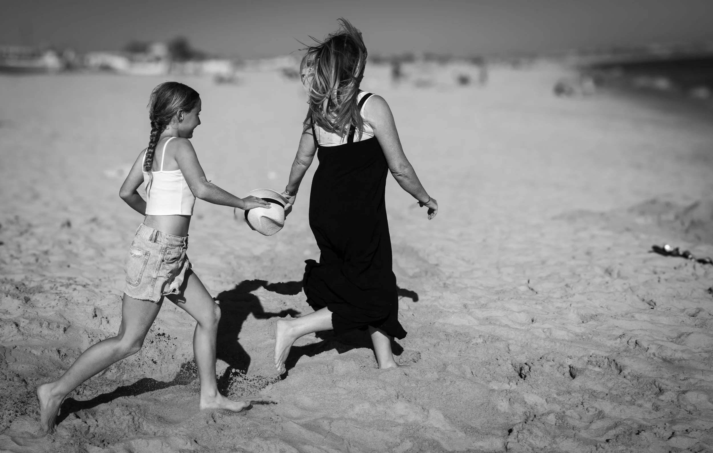 A mom and daughter playfully run on the beach by Tucson family photographer Michelle Molnar