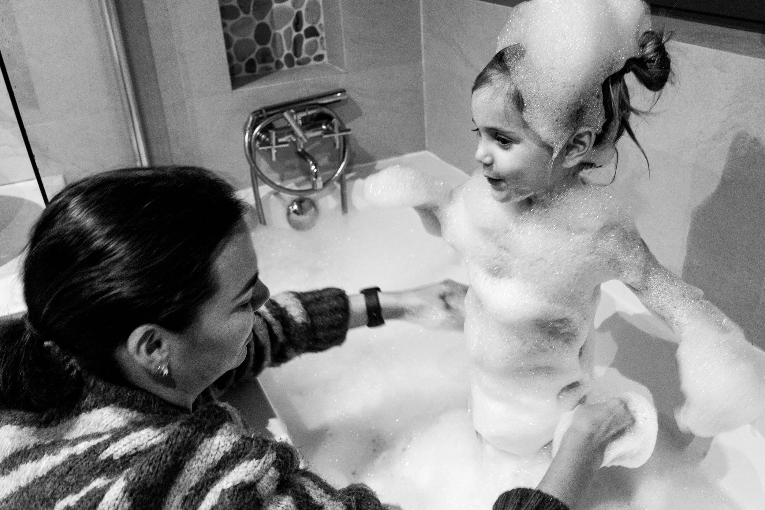 mom gives daughter bath during a Tucson family photo session.