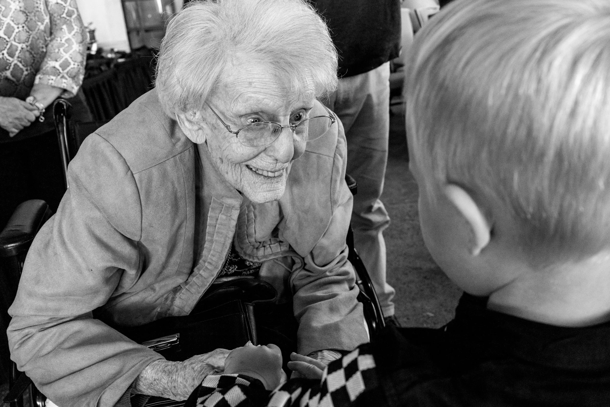 At a Tucson birthday party, documentary family photographer Michelle Molnar photographed a young boy holding his grandma's hands as she smiles at him.