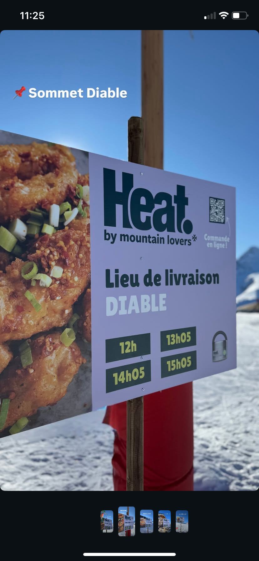 Panneau indiquant la livraison de nourriture à la montagne avec un horaire de 12h à 15h05, et un décor de montagne enneigée en arrière-plan.