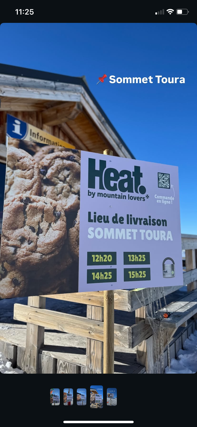 Panneau annonçant la livraison de cookies avec des heures de livraison et un fond de ciel bleu. Entrée d'un bâtiment en bois avec un panneau d'information.