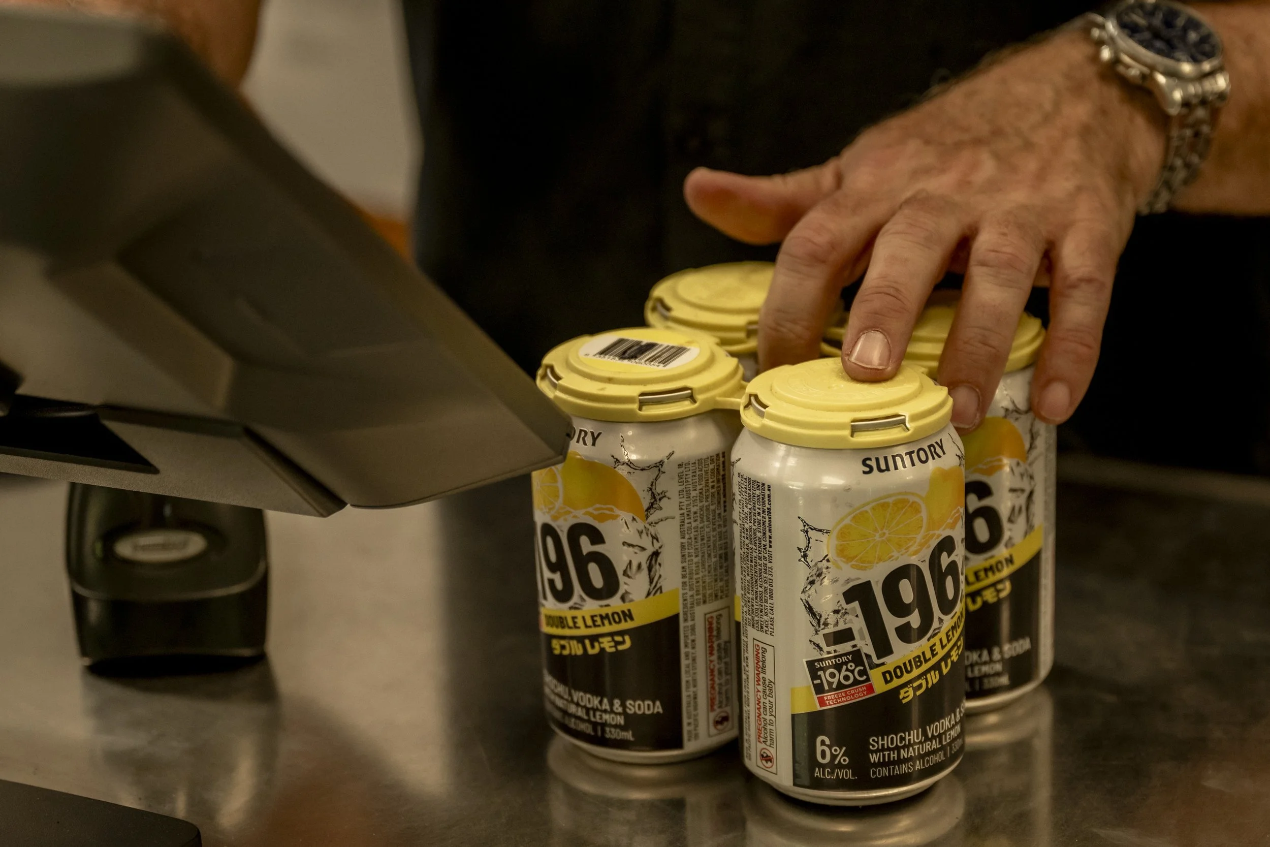 Customer purchasing Suntory 196 Double Lemon vodka cans at Brew Plus bottle shop counter in Busselton