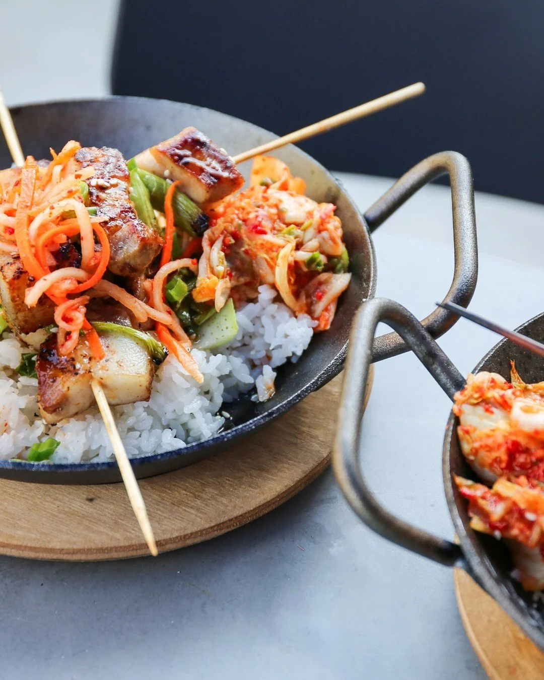 Not to be dramatic, but these skewers deserve your attention 🥢🔥

Choose Crispy Chicken or Crispy Pork Belly, both glazed in pineapple chili and served with green onions, blistered bok choy, edamame, garlic kimchi, sweet &amp; sour daikon salad, ste