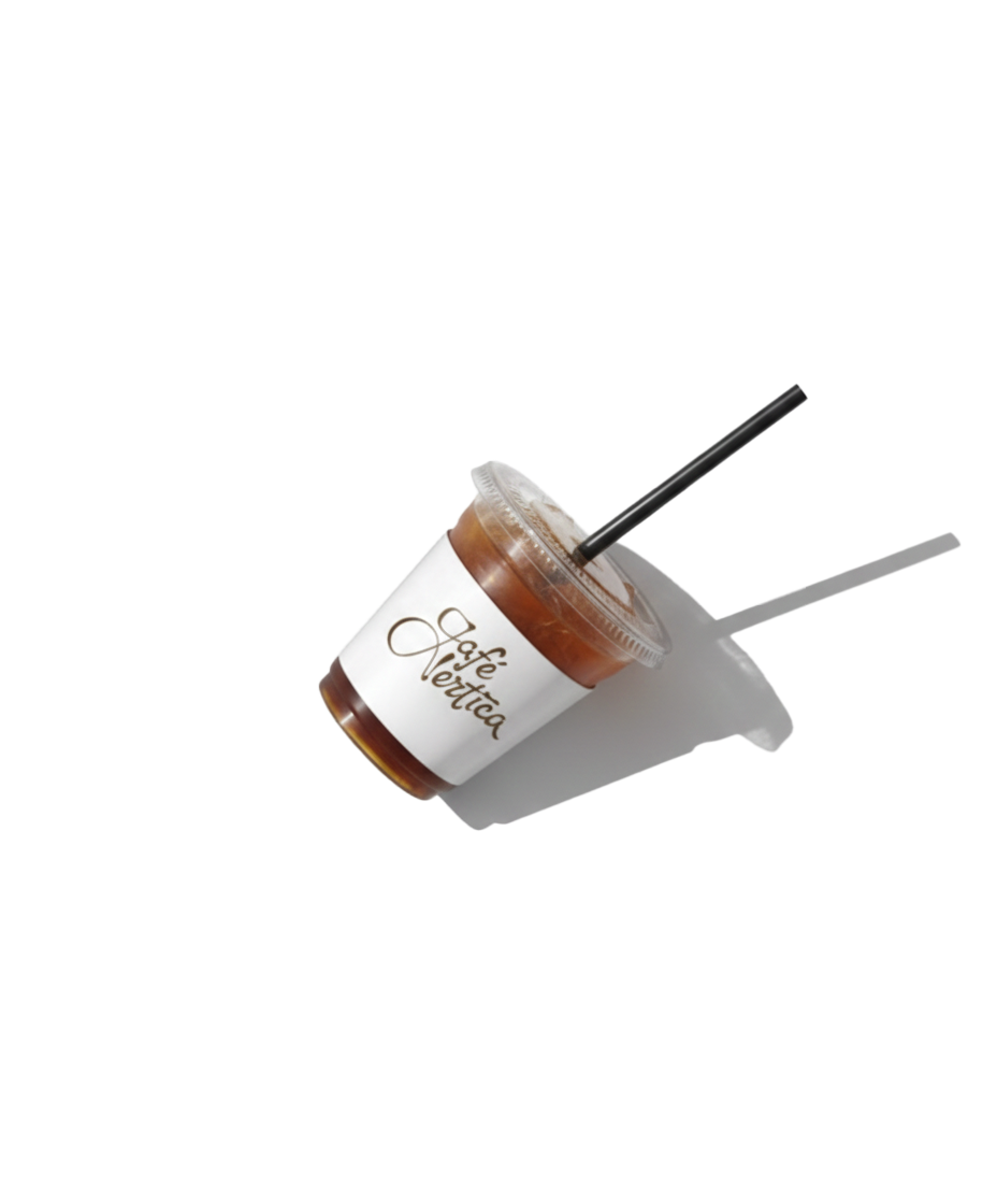 A plastic cup with iced coffee and two black straws, one straight and one bent, placed on a white surface with a shadow. The cup has a white label with the text 'Café Vertica' in brown.