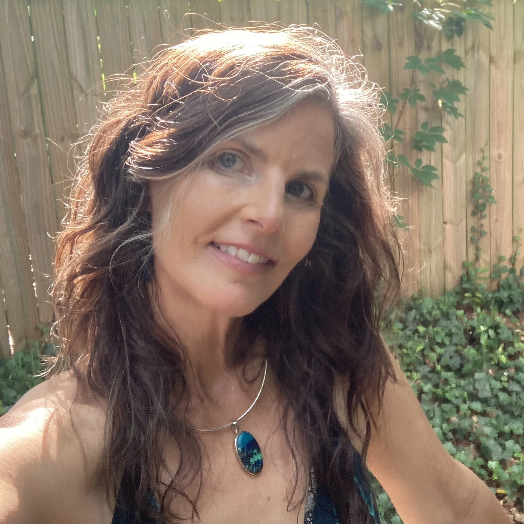 Tamara Albright, founder and creative director of Allvibe Creative, photographed outdoors in a garden setting.