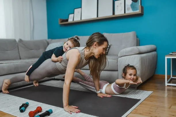family yoga class at home with mum and children doing plank pose together