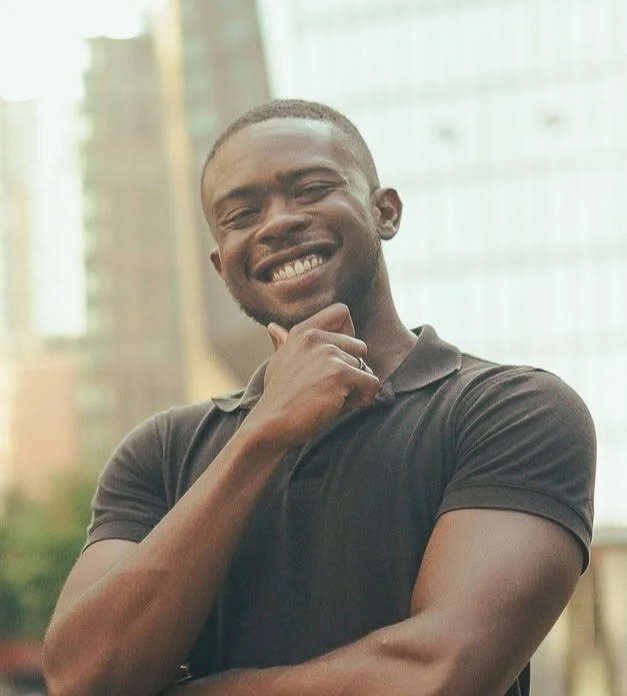 Smiling man in a black tshirt with city background