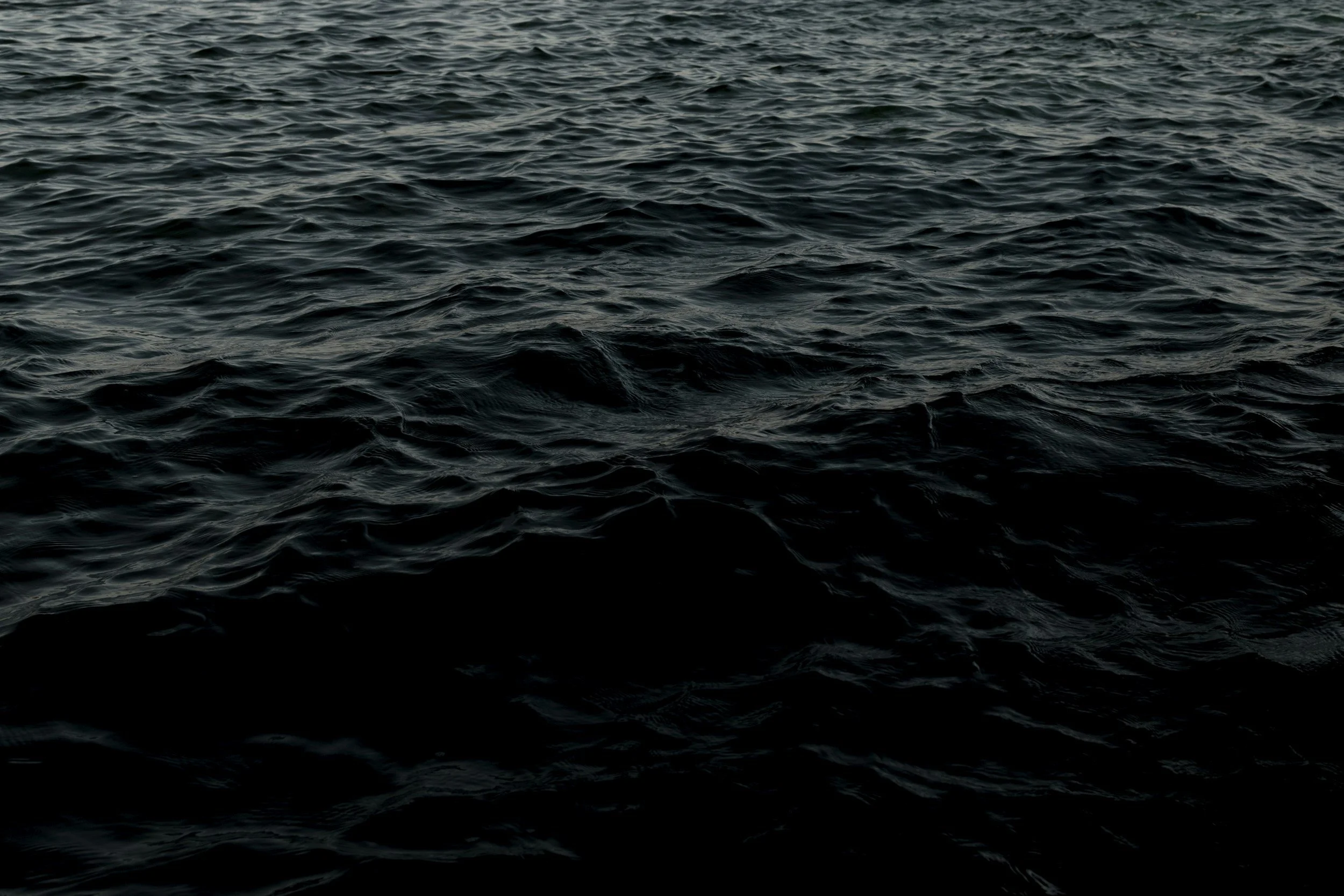 Dark ocean water with gentle movement, representing mindfulness, emotional flow, and grounding in therapy.
