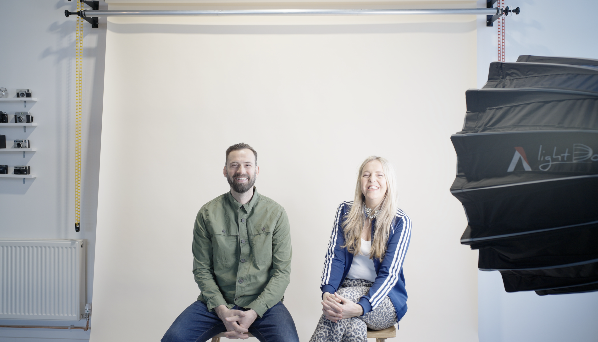male and female posing for the portrait photograph in front of a colourama in photography studio
