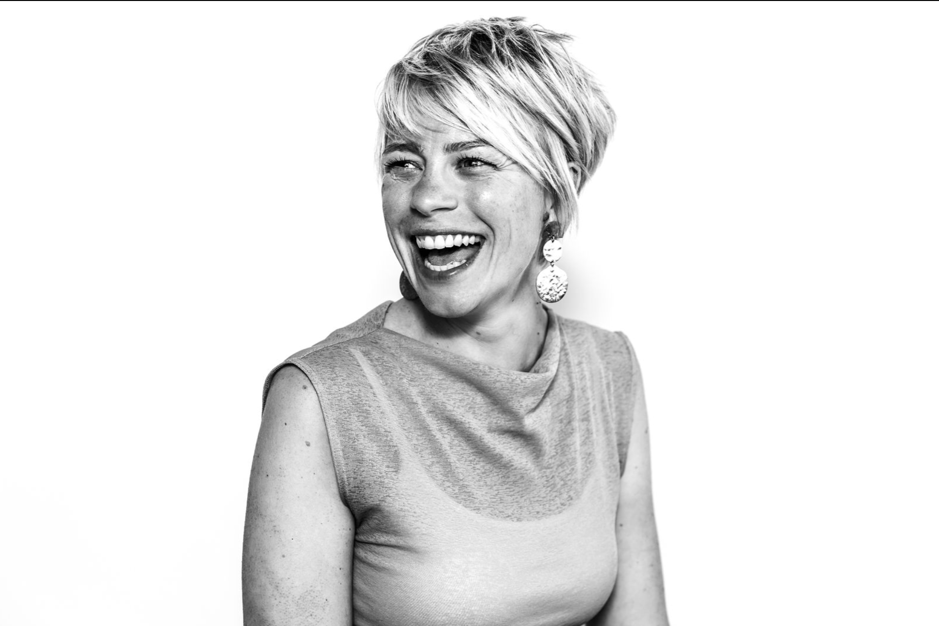 Black and white portrait headshot of lady smiling looking to the left of the frame
